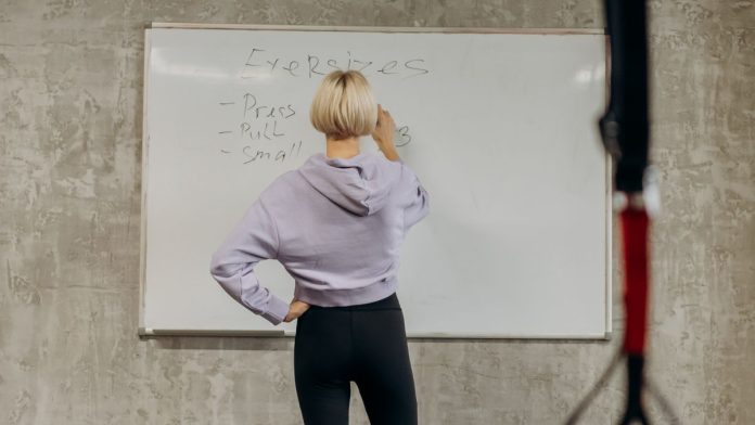 Person planning a weekly workout routine at the gym