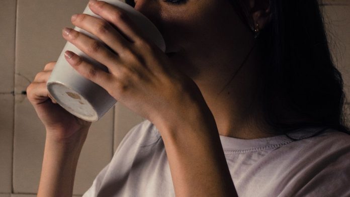 Woman holding a warm cup of coffee in the morning light