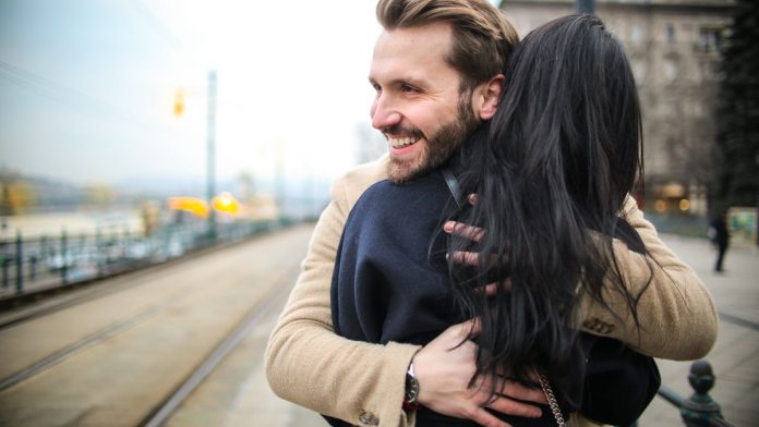 Happy couple embracing and laughing together outdoors
