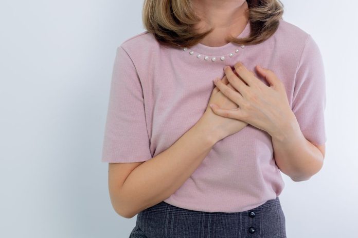 Woman with hands on her chest practicing self-compassion