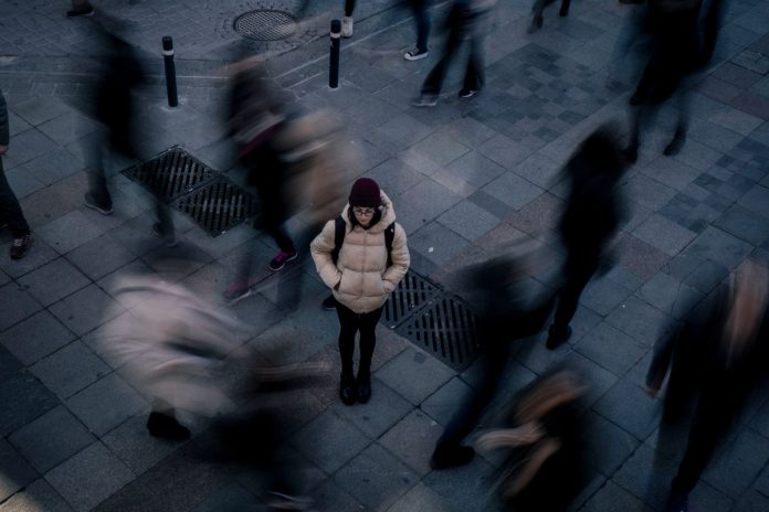 Woman standing calmly alone in a crowd, coping with social anxiety