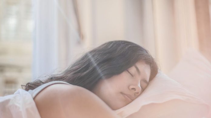Woman sleeping peacefully in bed moving through the stages of sleep