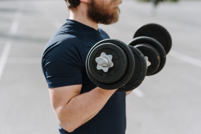 Man exercising with dumbbells to build muscle