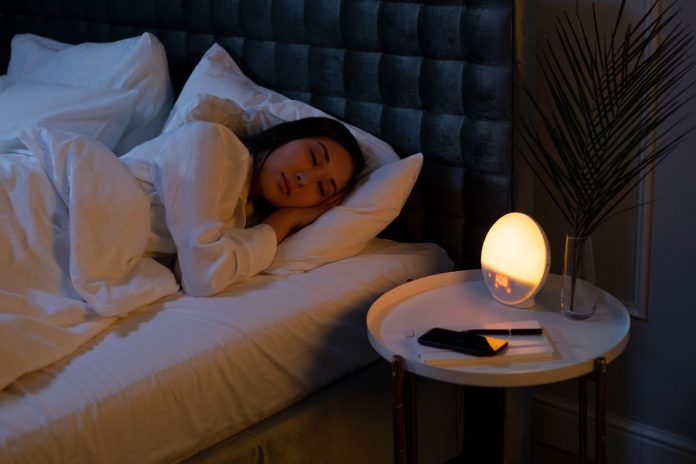 Woman sleeping peacefully on her side in bed, a healthy sleep position