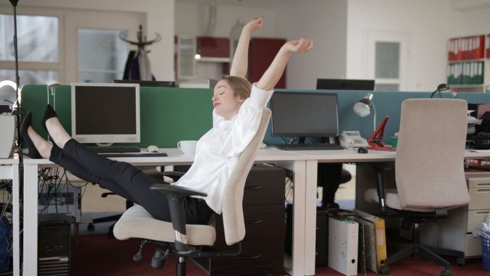 Person stretching at a desk in an office