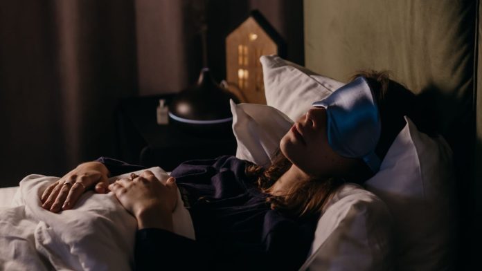 Woman sleeping peacefully in a calm, dark bedroom