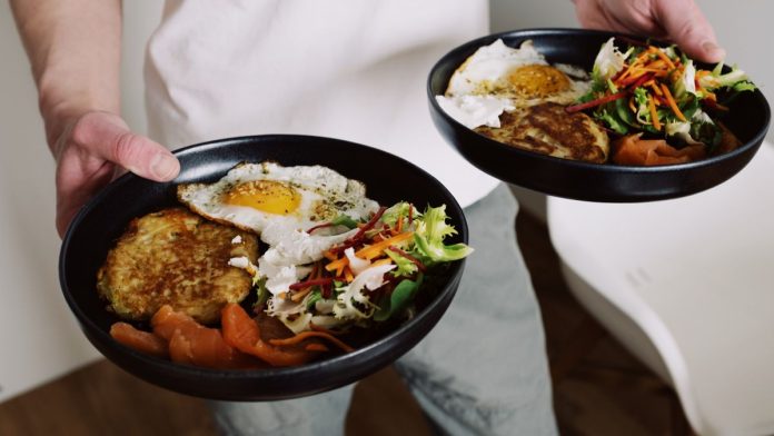 Person serving a balanced portion of food onto a plate