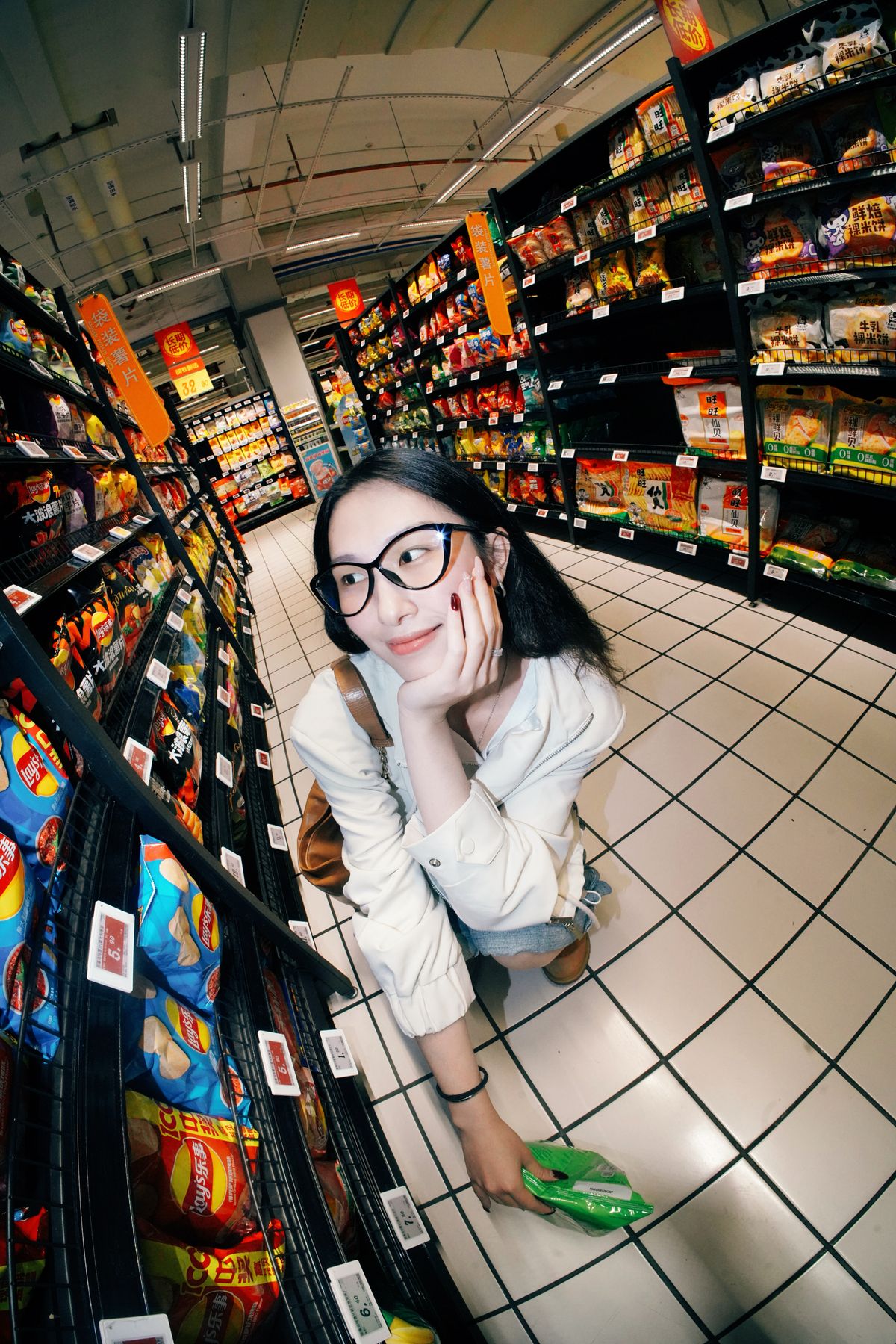 Young woman comparing ultra-processed snack options in a grocery aisle