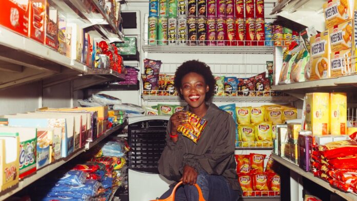 Woman choosing packaged snack foods in a supermarket aisle