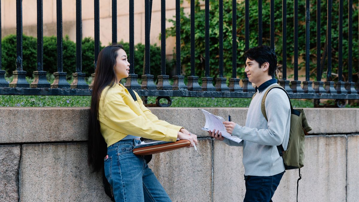 Two adult friends standing outdoors talking, building an adult friendship through conversation