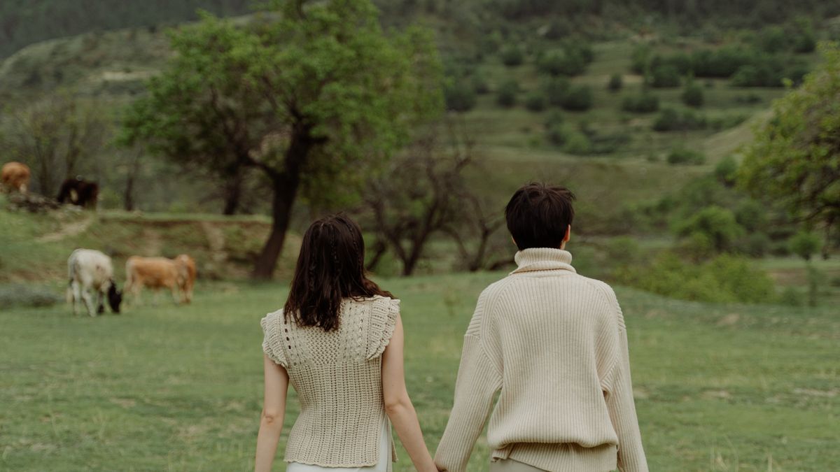 Two women walking through a field together, keeping an adult friendship alive