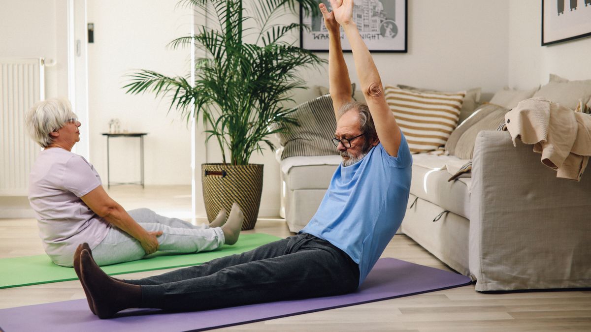 Couple exercising together on yoga mats, a habit linked to better sexual health