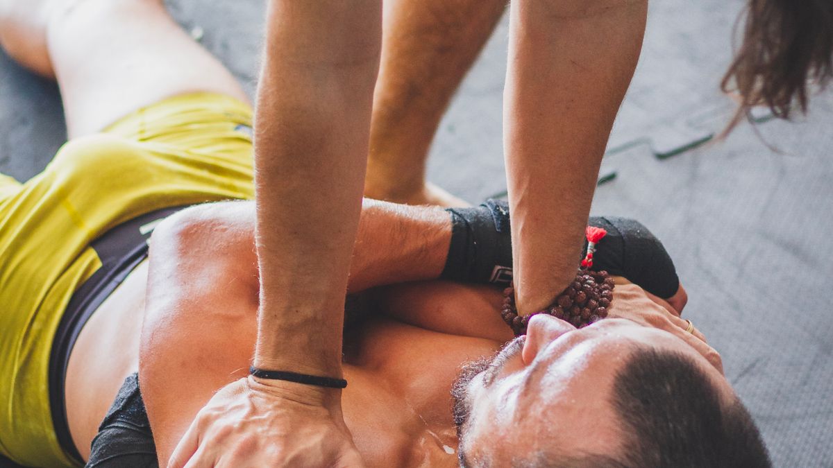 Trainer guiding an athlete through foam rolling for muscle recovery