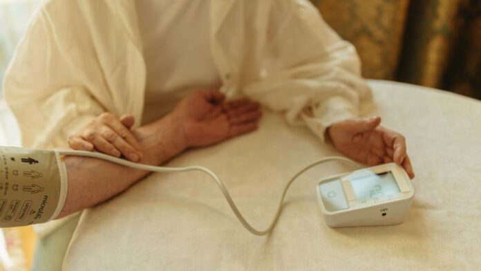Man checking high blood pressure at home with a digital monitor