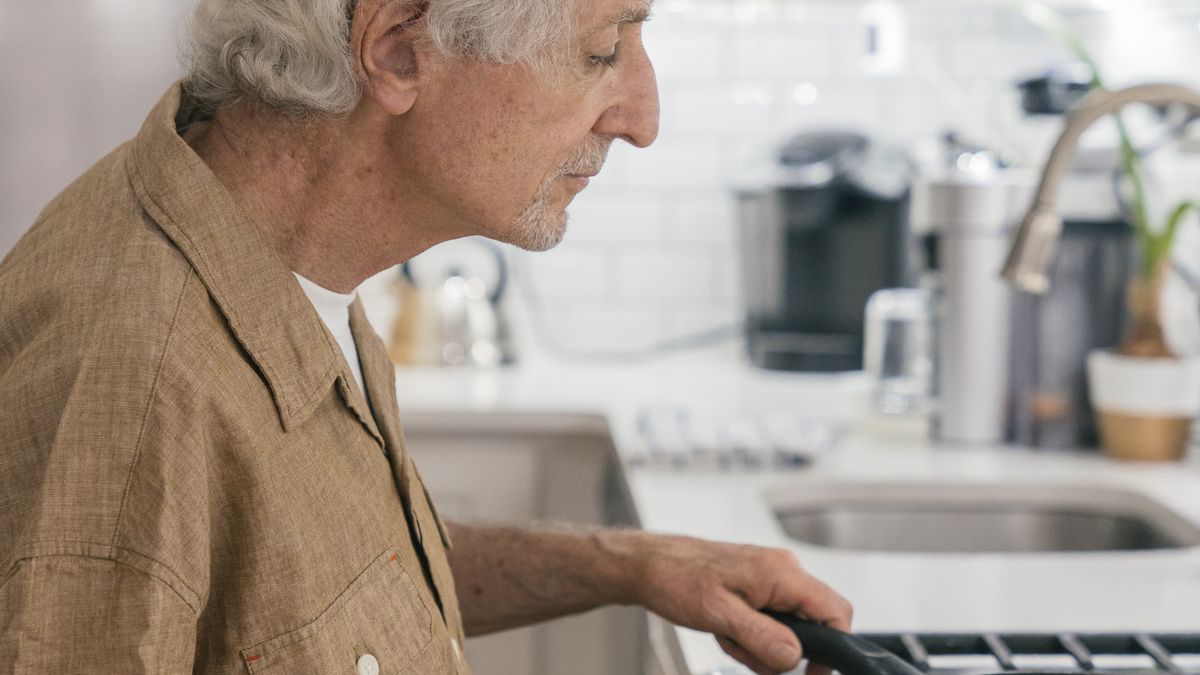 Older man cooking a low-sodium meal with fresh vegetables at home