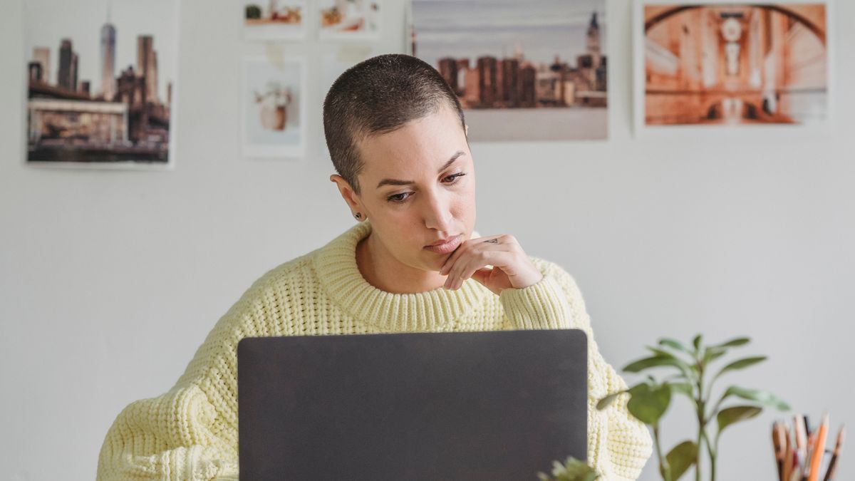 Woman with imposter syndrome second-guessing her work at a laptop
