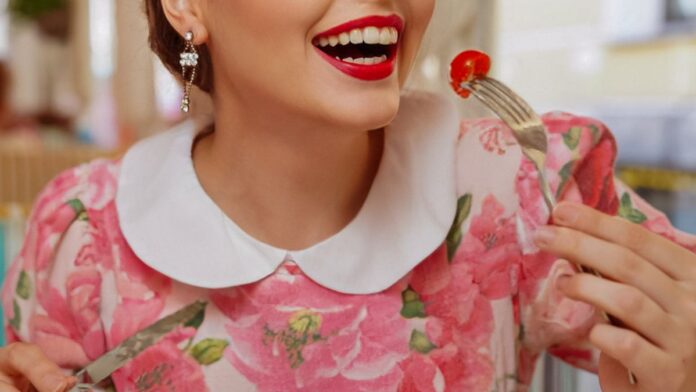 Smiling woman eating a fresh spinach salad rich in magnesium