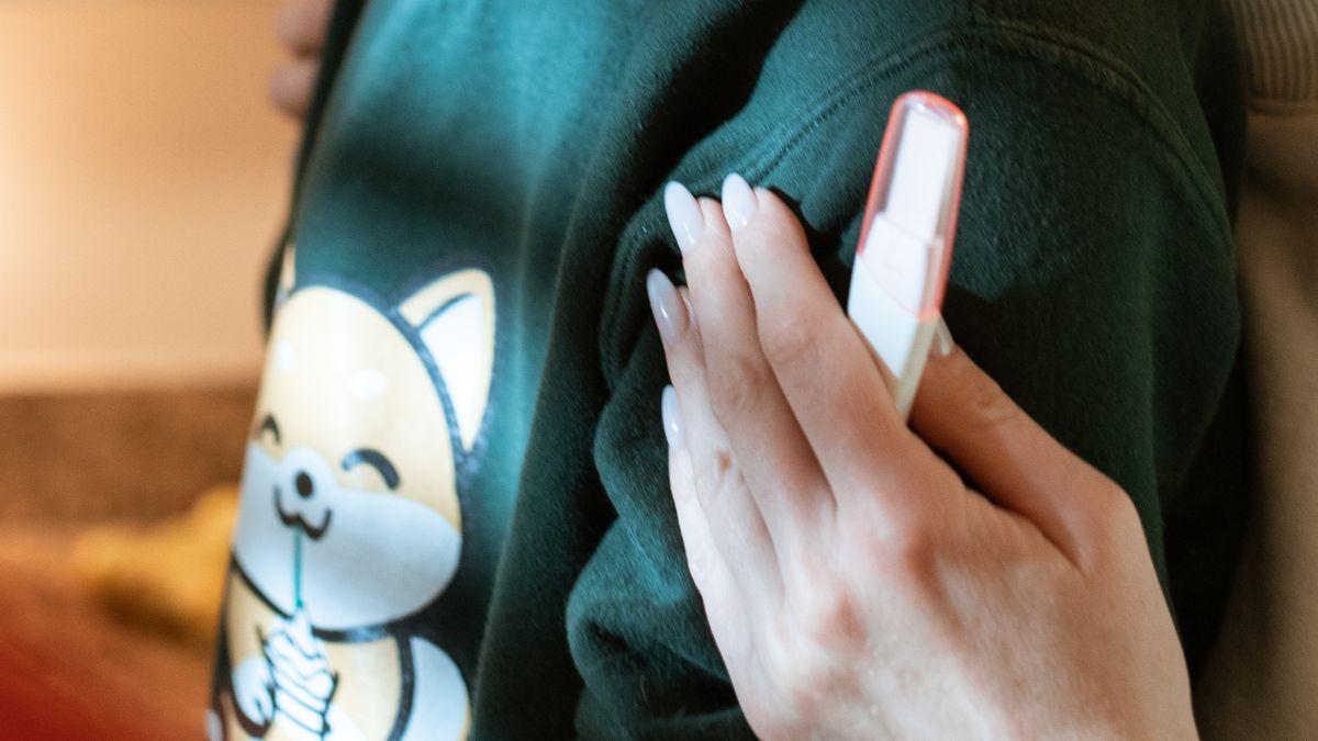 Woman holding a pregnancy test while hugging her partner