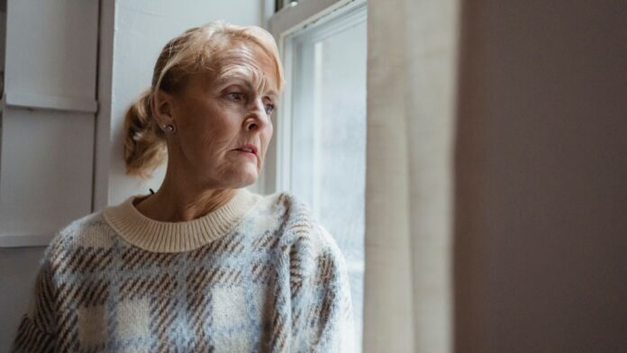 Woman looking out a window in low winter light, reflecting seasonal affective disorder