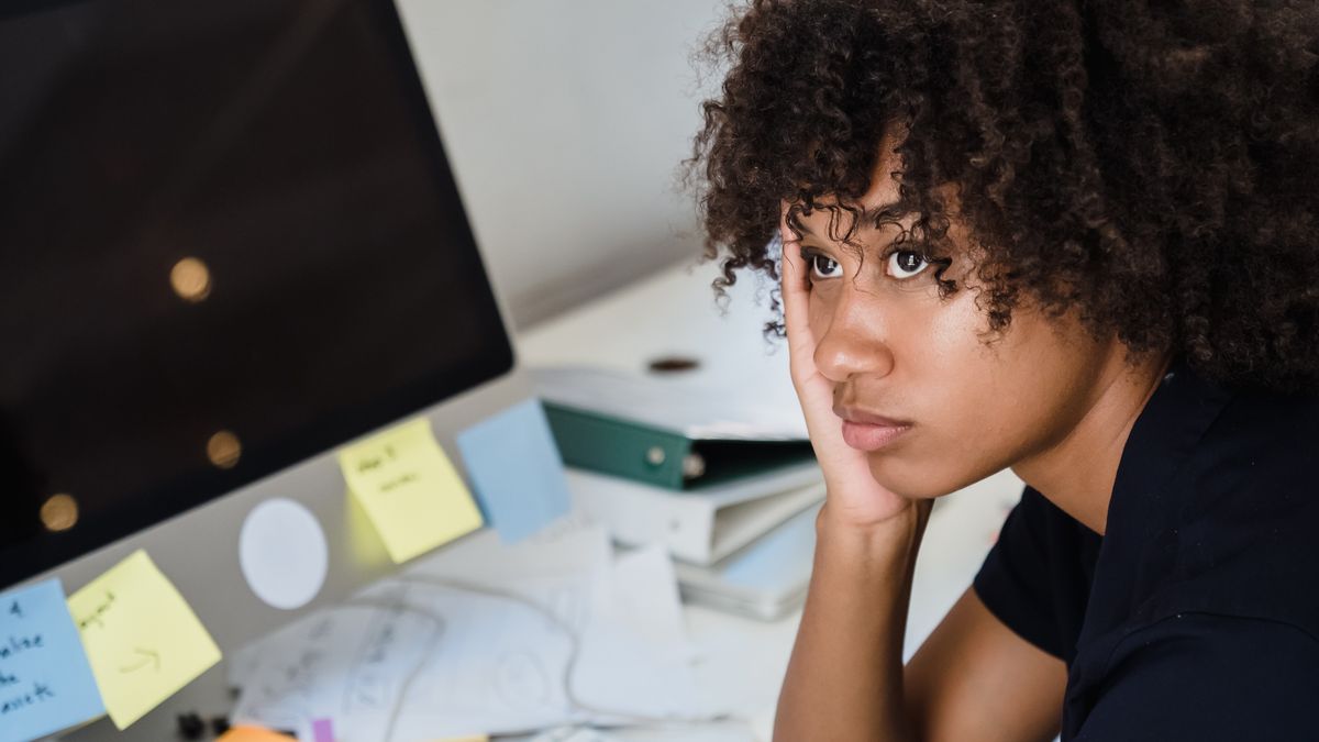 Tired woman at her work desk showing the daytime effects of social jet lag