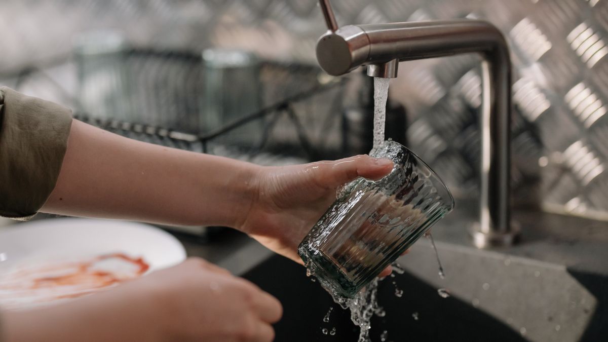 Pouring a glass of water, part of a daily routine to prevent kidney stones in men