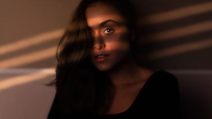 Woman with eyes closed enjoying warm sunlight on her face, a natural source of vitamin D