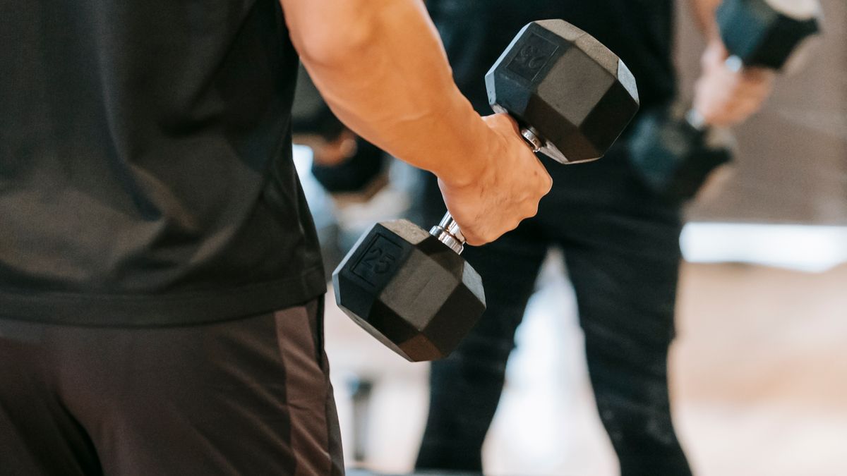 Man gripping a heavy dumbbell during strength training to improve grip strength