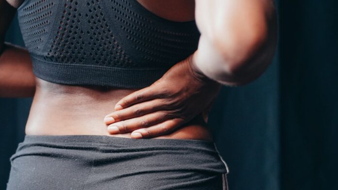 Man holding his lower back in pain, a classic sign of kidney stones in men