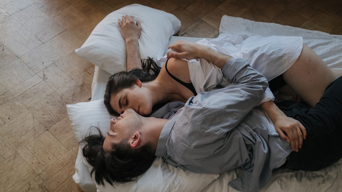 Couple resting close together in bed, keeping intimacy while sleeping apart