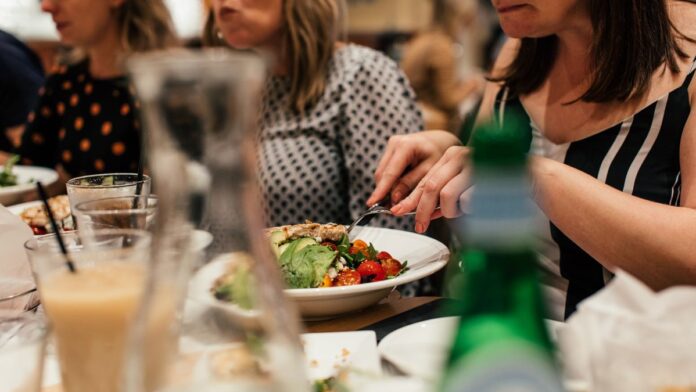 Person eating a bowl of plant protein rich salad at a table