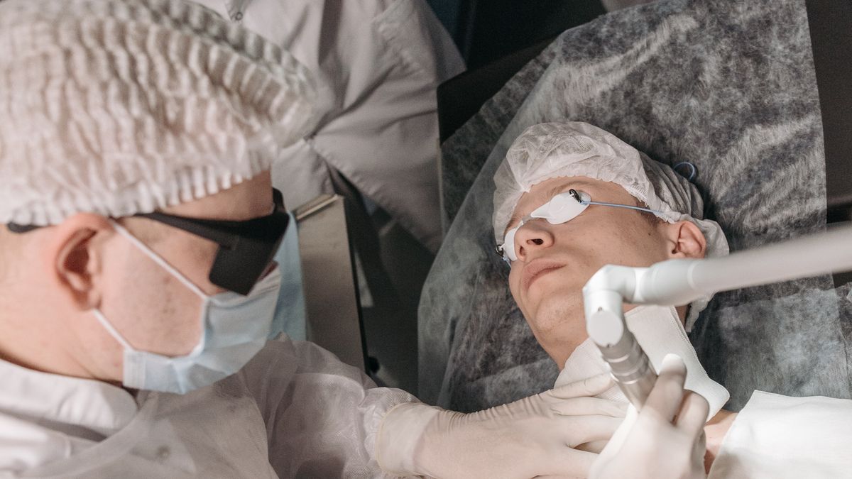 Clinician examining and removing a mole during a dermatology appointment