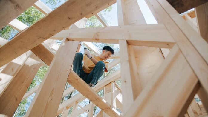 Man working outdoors in the sun at a construction site, a key skin cancer risk factor for men