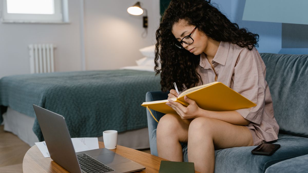 Young woman writing her honest feelings in a notebook to counter toxic positivity