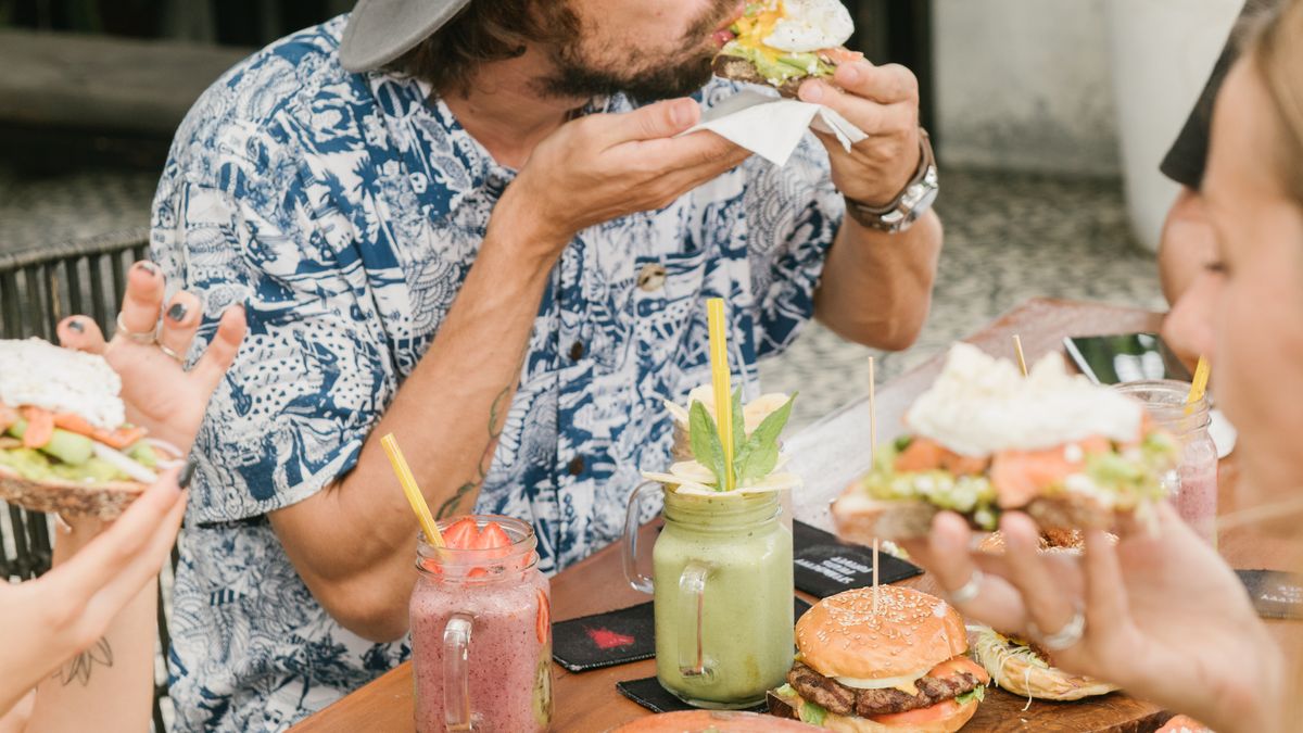 Friends sharing a large weekend meal at a table, a common source of weekend weight gain