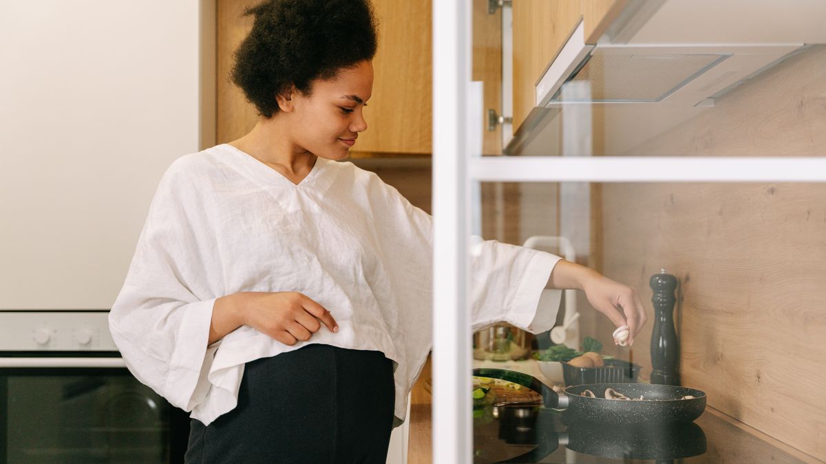Woman cooking a healthy meal at home on the weekend to avoid weekend weight gain