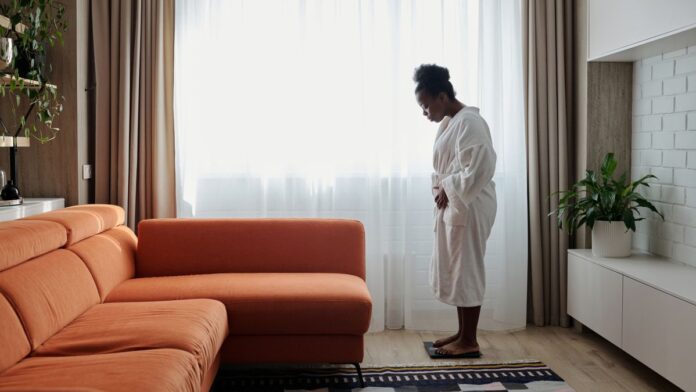 Woman standing on a bathroom scale at home checking her weight